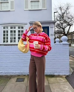 Outdoor street style shot of striped polo knitwear paired with high-waisted wide-leg trousers