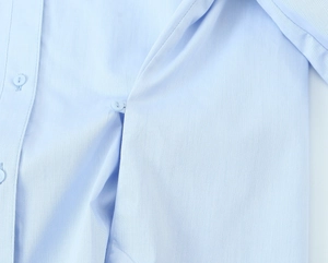 Detailaufnahme des hellblauen Twill-Stoffs und der passenden Knöpfe am Langarmhemd
