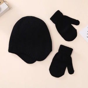 Detailed knit texture of baby winter earflap hat and mittens set in solid black