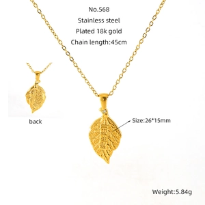 Macro shot of 18k gold plated leaf pendant with Chinese characters and texture details