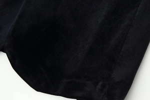 Gros plan sur la texture du tissu en velours noir montrant les fibres douces et la couture