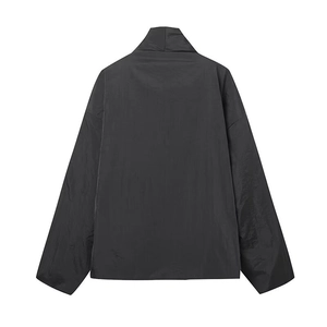 Vista posterior de chaqueta kimono negra con textura fina de tela y acabado elegante