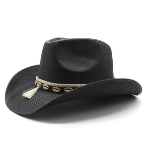 Détail d'un chapeau de cowboy noir en paille tissée avec coquillages et glands