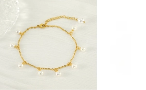 Detail of 18K gold stainless steel anklet featuring white pearls and lobster clasp