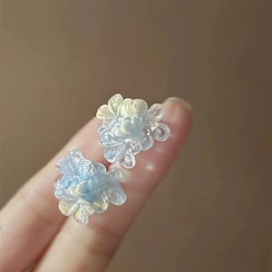 Macro shot of light blue layered flower earrings with a translucent jelly texture