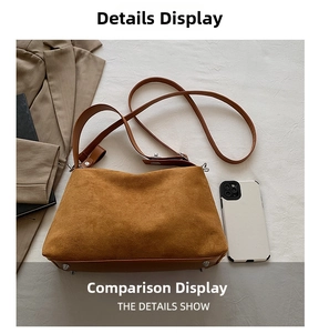 Détail du sac à bandoulière en daim marron avec pieds en métal à côté d'un smartphone