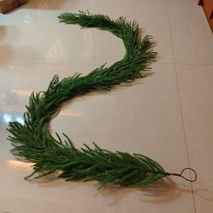 Close-up of artificial green cedar garland showing flexible structure and metal hook