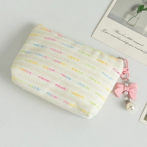 Detail of woven coin purse with colorful dots, pink bow and pearl pendant charm