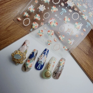 Detailed relief nail art stickers featuring rabbit, peach, and pearl charms for manicure
