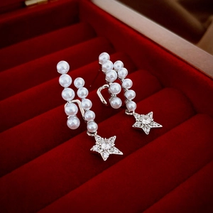 Elegant silver earrings with pearls and zircon star pendant on a red velvet jewelry box