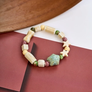 Detail showing colorful ceramic beaded bracelet with geometric stars and cylinder shapes