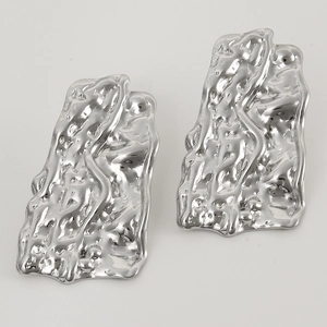 Macro detail of silver irregular earrings with liquid lava texture and polished finish