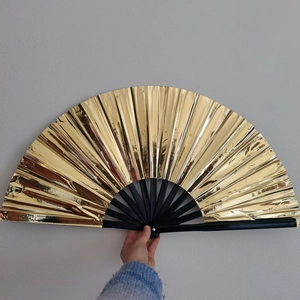 Detail of 33cm gold Kung Fu folding fan with black bamboo ribs and laser finish
