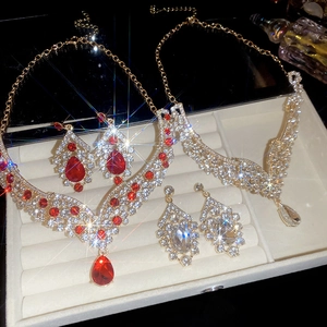 Detailed view of elegant gold and silver bridal jewelry sets with pear-cut crystal drops