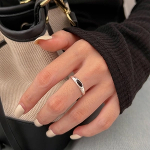 Minimalist 925 sterling silver ring with oval black onyx gemstone on model's hand