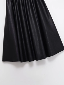 Detailed macro view showing the fine grain texture of the black matte faux leather skirt hem