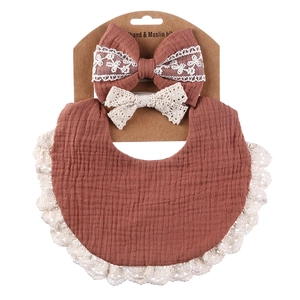 Detailed set of brown muslin baby bib and lace headband on display packaging card