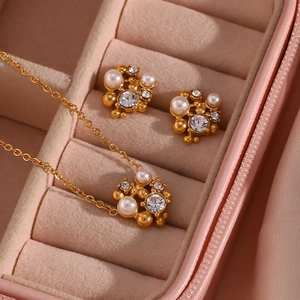 Detail of floral gold jewelry set with pearls and crystals in a pink velvet box
