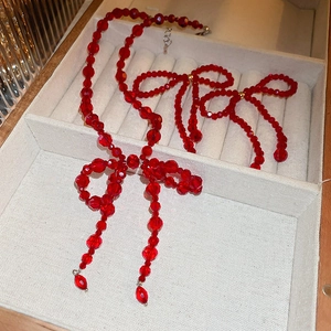 Boucles d'oreilles nœud en cristal rouge vintage avec pompons sur plateau à bijoux