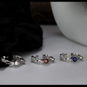 Close-up of three s925 silver square rings with clear, red, and blue gemstones
