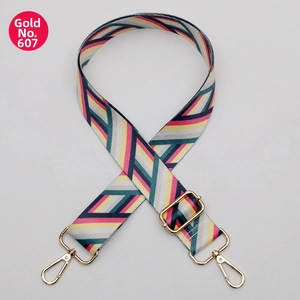 Detail of adjustable geometric woven shoulder strap with gold metal hooks and hardware