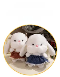 Detail of plush white bunnies wearing red and blue plaid dresses with soft fur texture