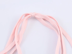 Gros plan des bretelles en tulle rose avec des finitions de couture doubles détaillées