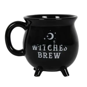 Detail of black ceramic Witches Brew cauldron mug featuring moon and stars patterns