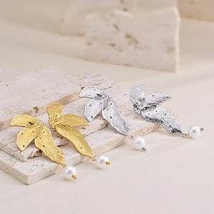 Irregular leaf earrings in gold and silver finish with white pearls on a stone base