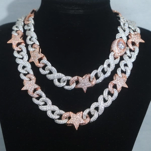 Close-up of hip hop Cuban link necklaces with iced-out star and eye pendants on a black bust