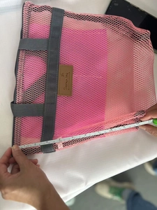 Borsa da spiaggia in rete rosa con manico grigio e metro che misura 33 cm di larghezza