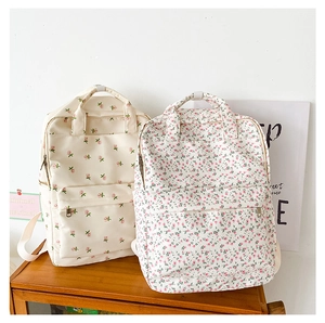 Close-up of floral backpack details with front zipper pocket and side water bottle holder