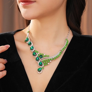 Close-up of vintage silver necklace with green waterdrop rhinestones on female model