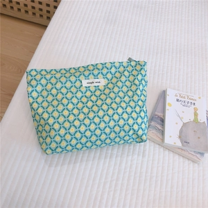 Detail of floral cotton makeup bag with yellow blossoms and a simple wish label