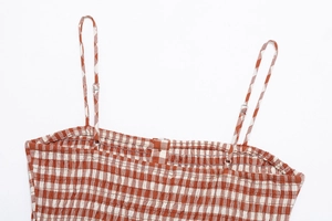 Detail of rust red gingham camisole with thin straps and smocked elastic back