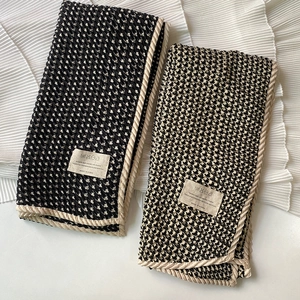 Houndstooth crinkle scarf in black and brown with woven trim on white fabric
