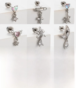 Macro view of silver titanium steel heart and cross earrings with zircon details