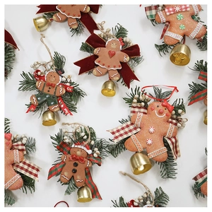 Detail of gingerbread man Christmas ornaments with pine needles and festive bells