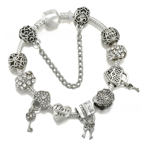 Detail of silver-plated charm bracelet with heart pendants and I Love You engraving
