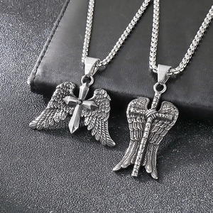 Macro shot of silver titanium steel cross wings and sword pendants on black leather