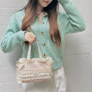 Gros plan d'un sac cabas floral rose avec volants en dentelle blanche porté par un mannequin