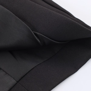 Elegant black double-breasted blazer showing textured fabric and ribbed knitting detail