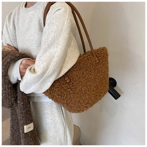 Detail shot of brown plush faux lamb wool tote bag featuring soft textured grainy material