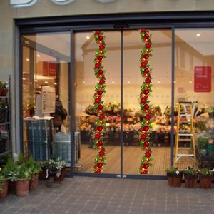 Détail de suspensions de Noël avec aiguilles de pin, boules rouges et cloches dorées