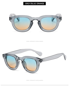 Detail of grey transparent round sunglasses with blue-orange gradient lenses and metal rivets