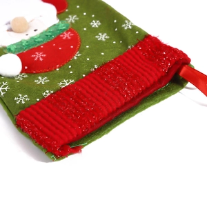 Close-up of small Christmas stocking featuring Santa applique and fuzzy green cuff detail