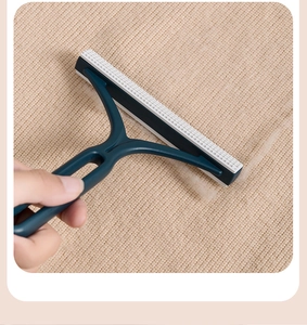 Dettaglio del levapelucchi manuale blu scuro che rimuove i pallini dal tessuto in maglia