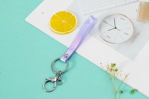 Close-up of a purple gradient iridescent PVC lanyard with a metal keychain and lobster clasp