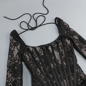 Détail de la robe en dentelle noire à manches longues avec décolleté carré et laçage corset