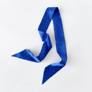 Detail eines dunkelblauen Satin-Schals mit weißen Punkten und seidiger Textur